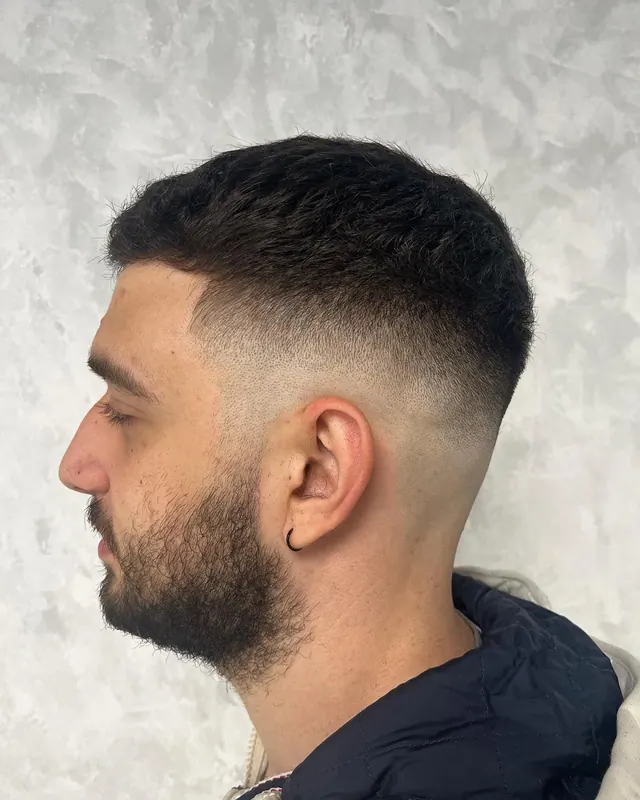 A crop with a skin fade and a beard